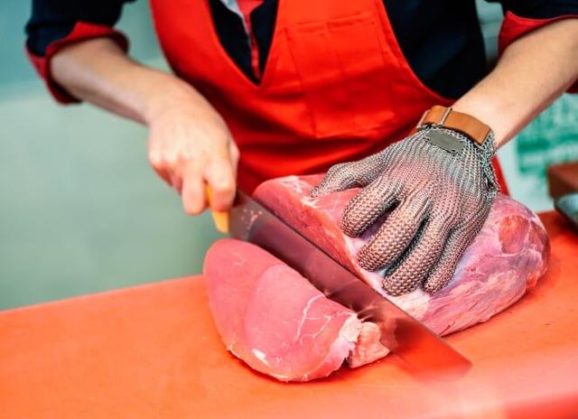 Mulher cortando carne fresca no açougue